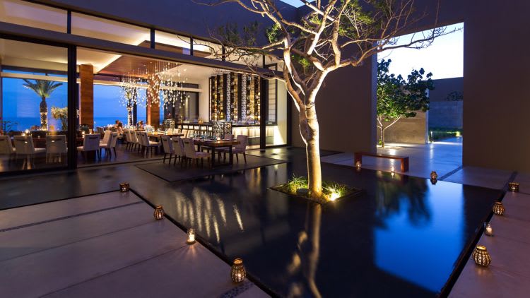 Upscale restaurant courtyard at JW Marriott Los Cabos Beach Resort & Spa featuring open-air design, water feature, and ocean views—ideal for MICE group dining, executive luncheons, and incentive program meals in Baja California Sur.