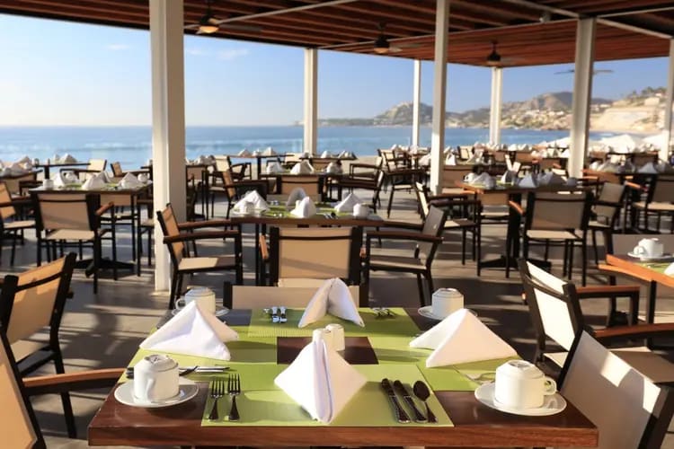 Oceanview restaurant at Krystal Grand Los Cabos featuring outdoor dining setup with white tableware and coastal scenery—ideal for MICE luncheons, networking breakfasts, and incentive program meals in Baja California Sur.