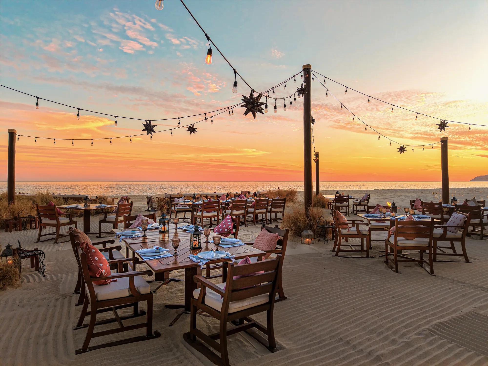 Beachside dining setup at Las Ventanas al Paraíso featuring lantern-lit tables, string lights, and sunset ocean views—ideal for MICE welcome dinners, incentive celebrations, and executive networking events in Baja California Sur.