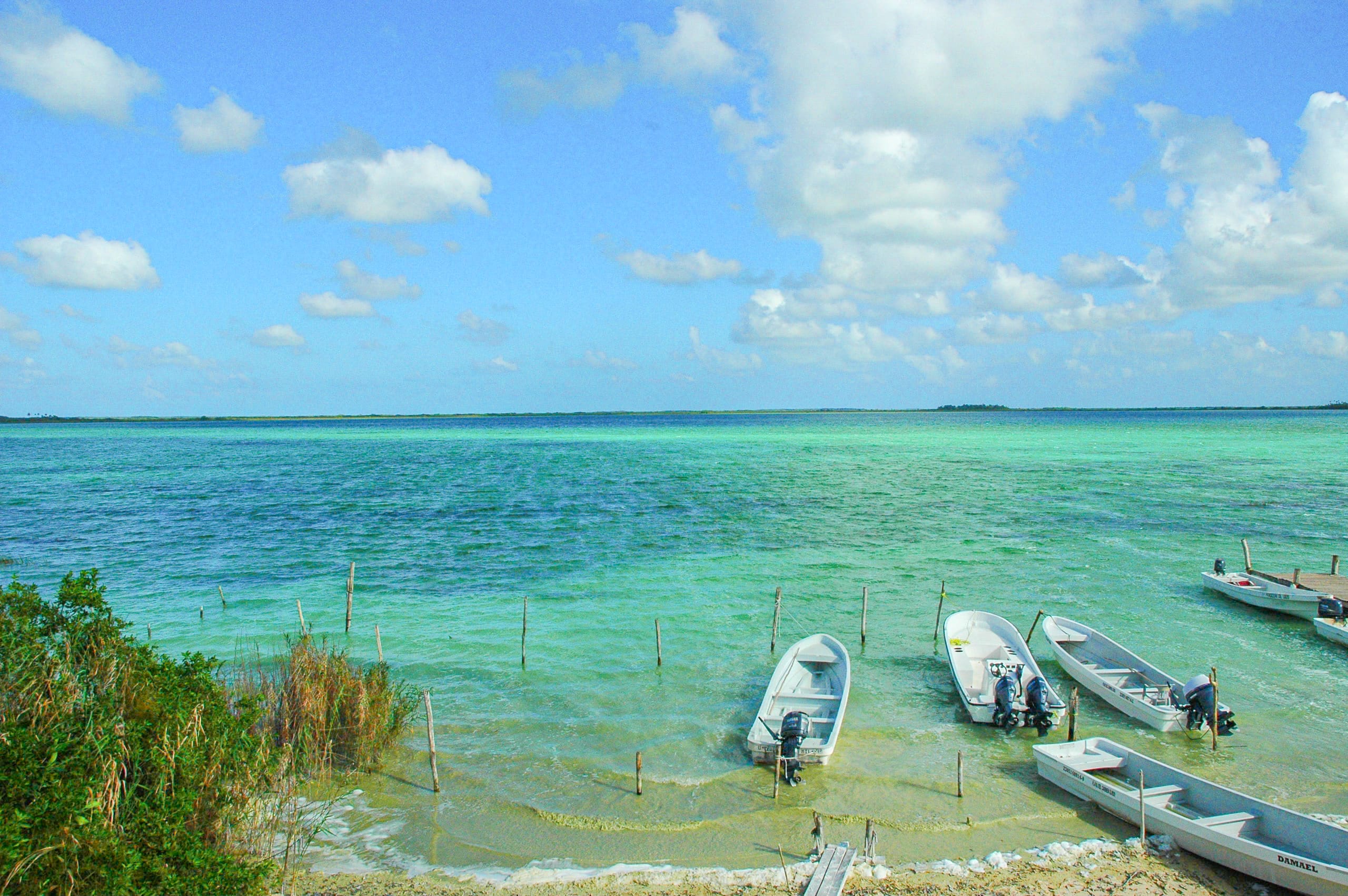 Small boats floating in calm turquoise lagoon waters of Riviera Maya, Mexico – a serene coastal setting perfect for MICE destination events, corporate boat excursions, incentive experiences, and private meetings by the sea.