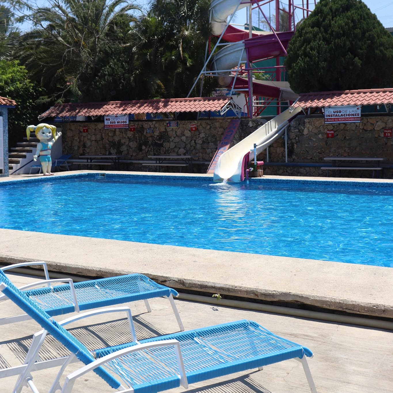 Family-friendly water park with slides, lounge chairs, and safety signage—ideal for MICE incentive programs, team-building activities, and group leisure events in tropical destinations.