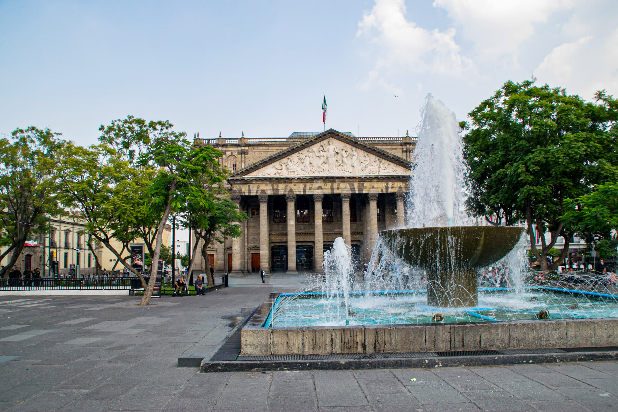 The iconic Teatro Degollado in Guadalajara's historic center, with a water fountain in the foreground. This renowned neoclassical theater is a prime venue for cultural events and gala dinners for incentive travel groups and MICE attendees. The image showcases the city's blend of historic beauty and modern event capabilities.