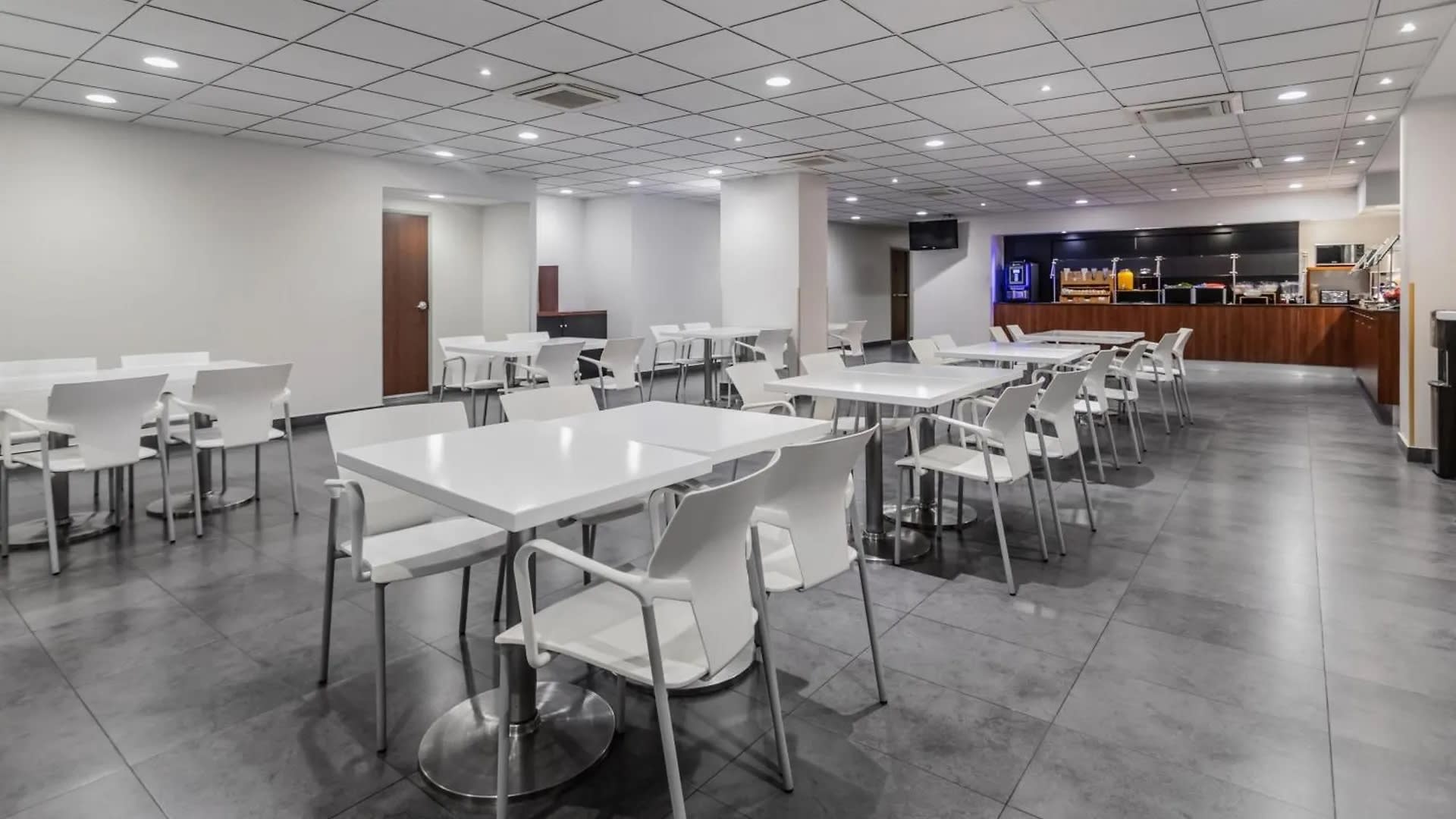 Bright cafeteria at City Express Oaxaca with seating and beverage stations, ideal for MICE guests during meetings and incentive travel programs in Mexico.