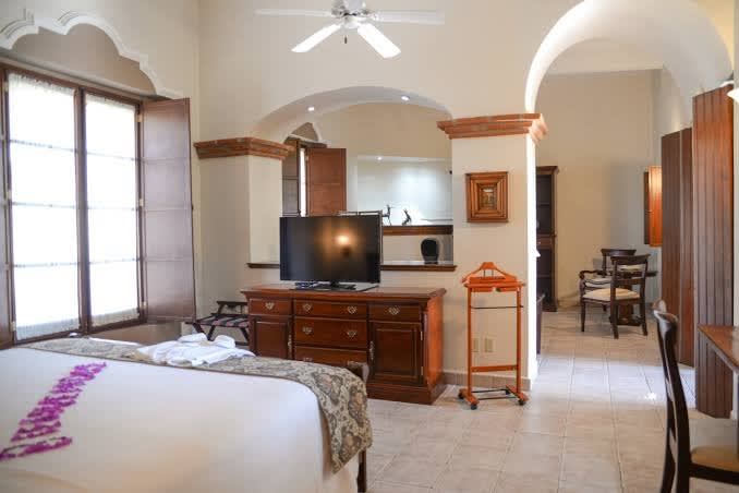 Elegant suite at Hotel Hacienda Los Laureles Spa in Oaxaca with floral decor, seating area, and natural light—ideal for MICE guests seeking comfort and wellness.