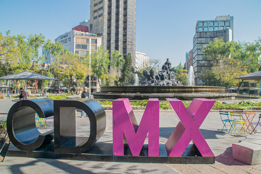 The large "CDMX" sign in Mexico City, with the Cibeles Fountain and modern buildings in the background. The sign is a popular photo spot for visitors and highlights the city’s vibrant, modern identity, making it a perfect destination for MICE industry travel and events.