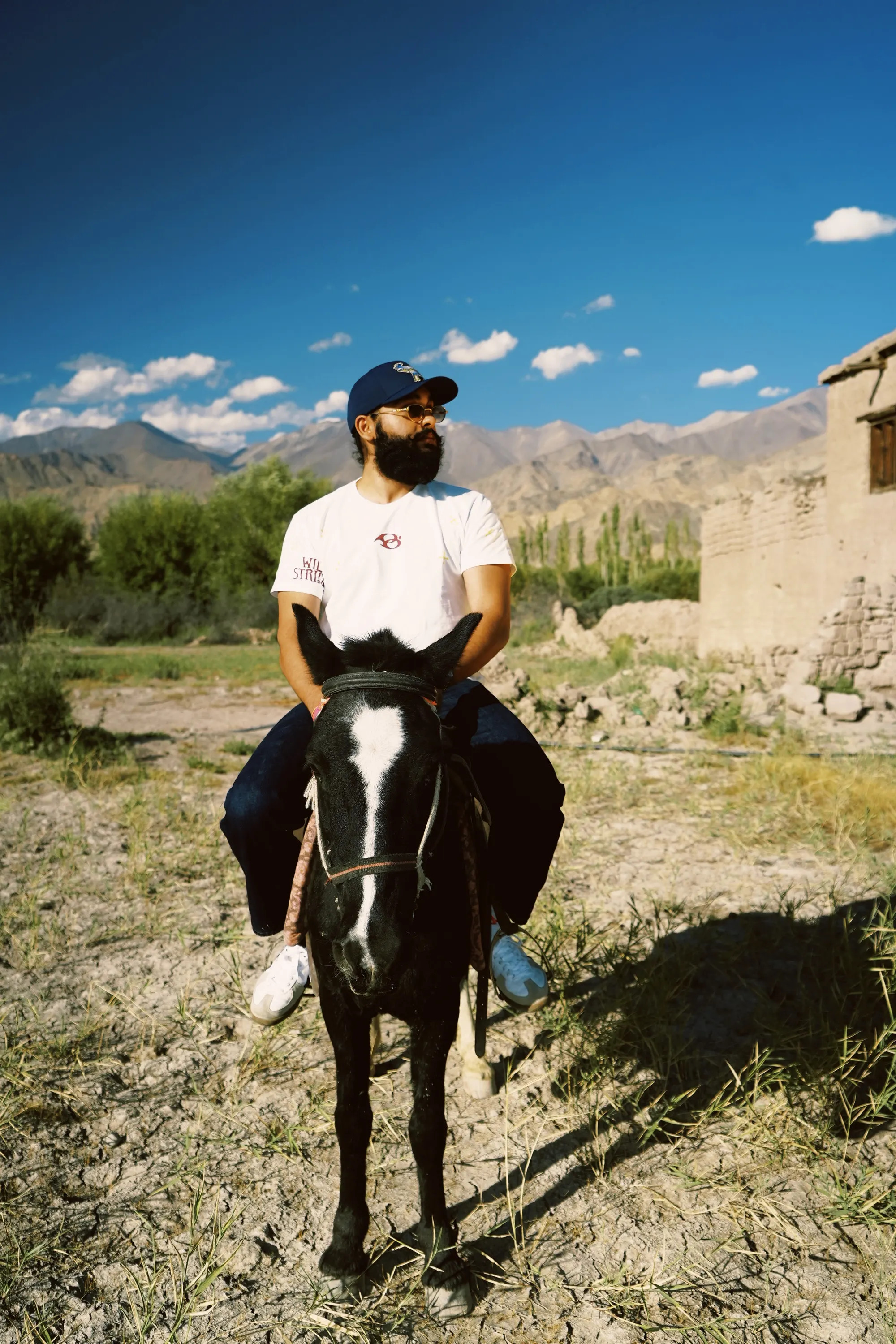 Wild Strides Tee in Ivory, front, worn on horseback in Ladakh