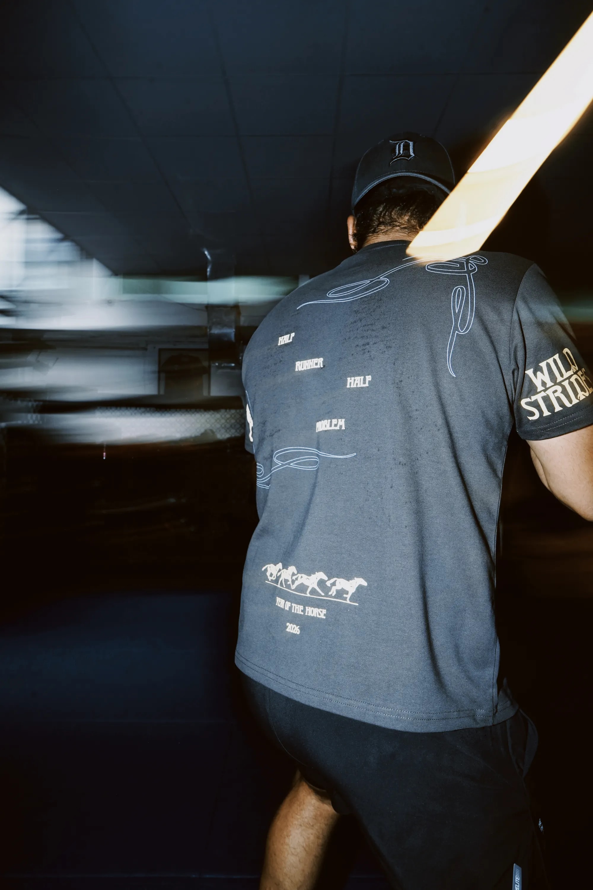 The Wild Strides Tee in Ash, worn, back print