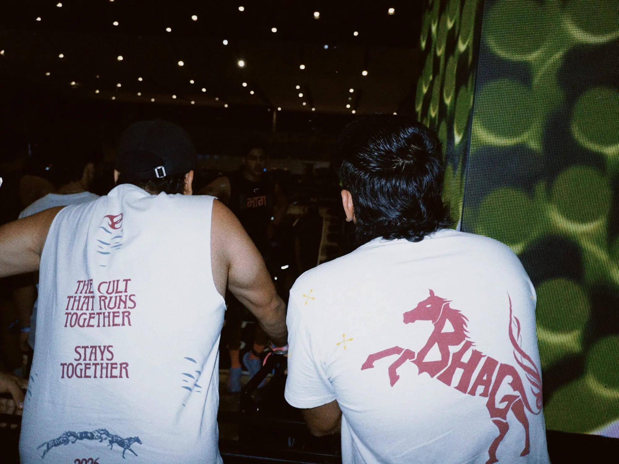 The भाग Muscle Tank and the Wild Strides Tee in Ivory, both backs