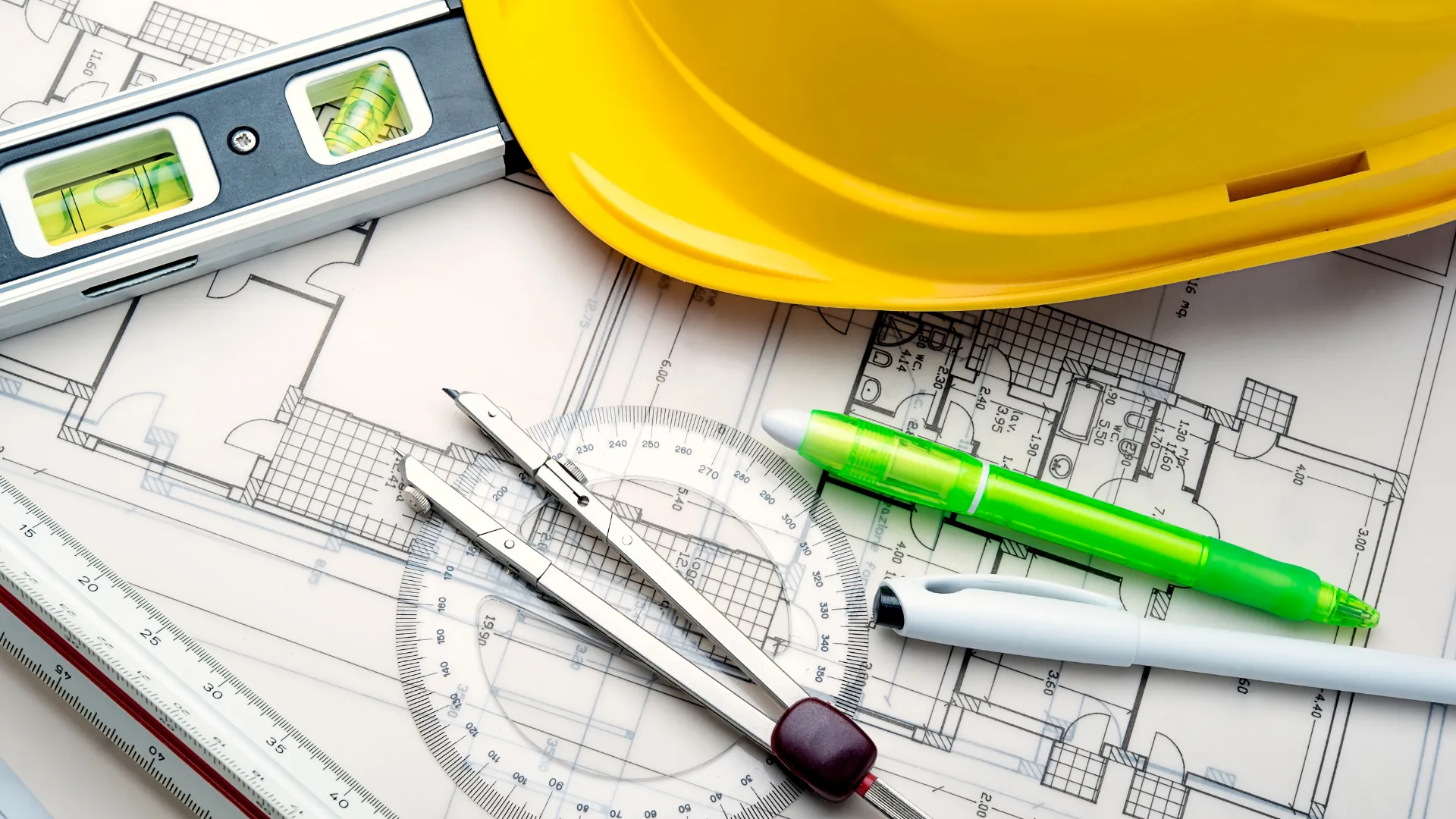 Architect sketching a floor plan beside a building model