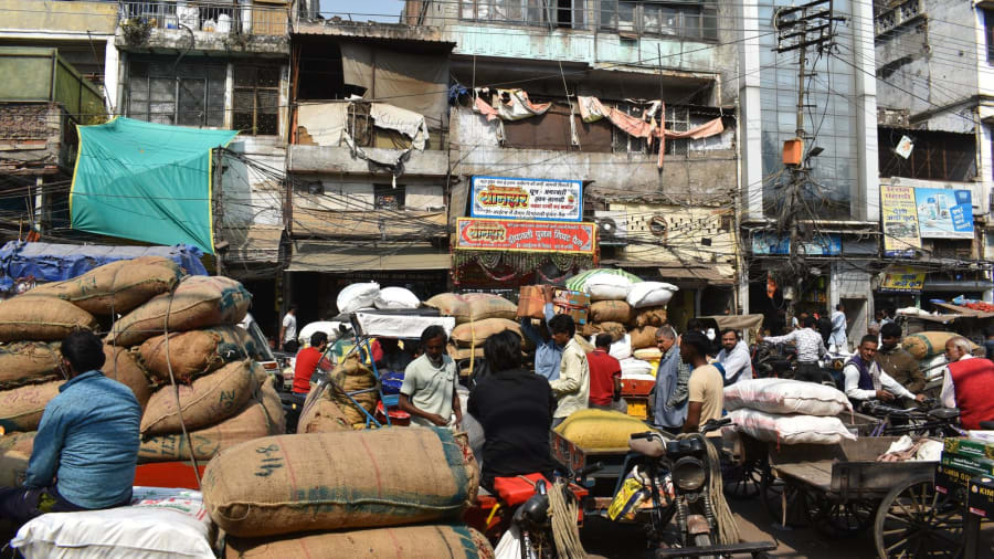 Sacks of goods on handcarts and traders in the crowded Khari Baoli wholesale market, Old Delhi
