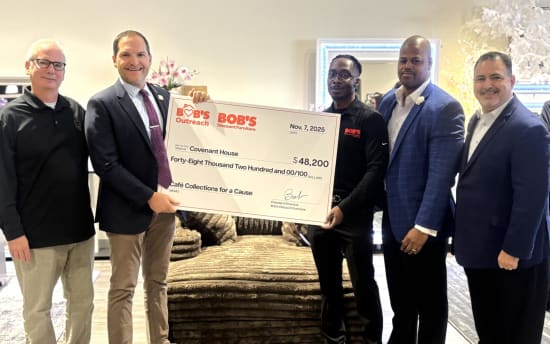 Group of six men holding a large check from Bob's Discount Furniture dated Nov. 7, 2025, for $48,200 payable to Covenant House for Café Collections for a Cause.