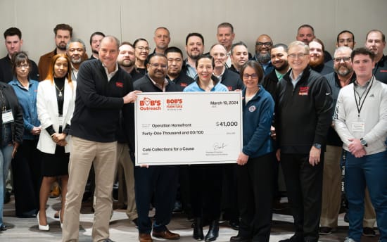 Group of people holding a large check from Bob's Discount Furniture dated March 19, 2024, for $41,000 to Operation Homefront, supporting Café Collections for a Cause.