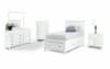 White coordinating bedroom furniture with storage bed, dresser, mirror, chest, and nightstand.