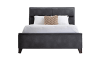Dark gray upholstered bed with white bedding and a beige accent pillow.