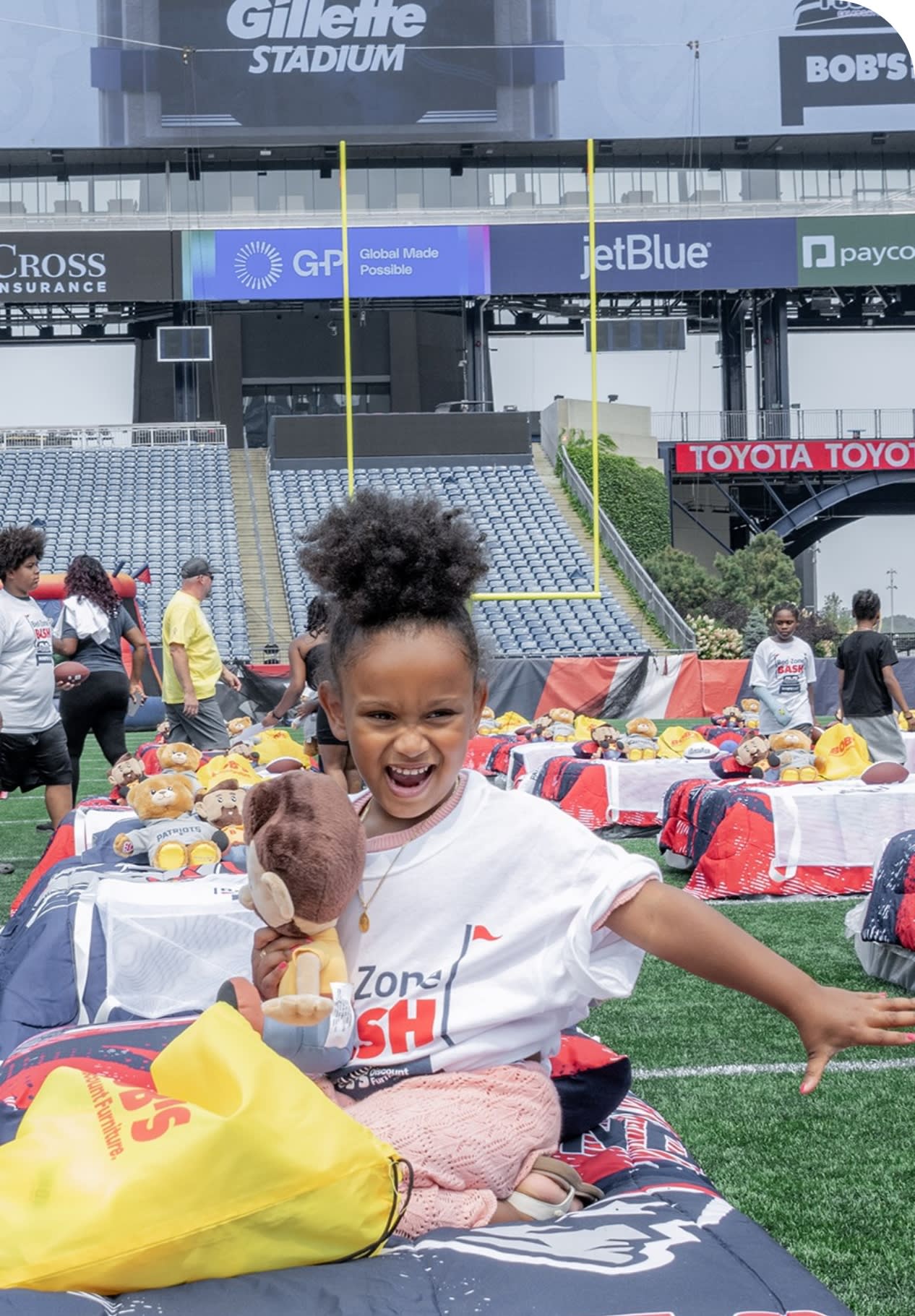 Young child on a bed in a stadium event.