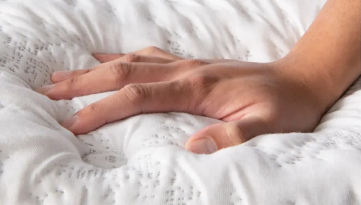 Hand pushing on an ultra plush mattress