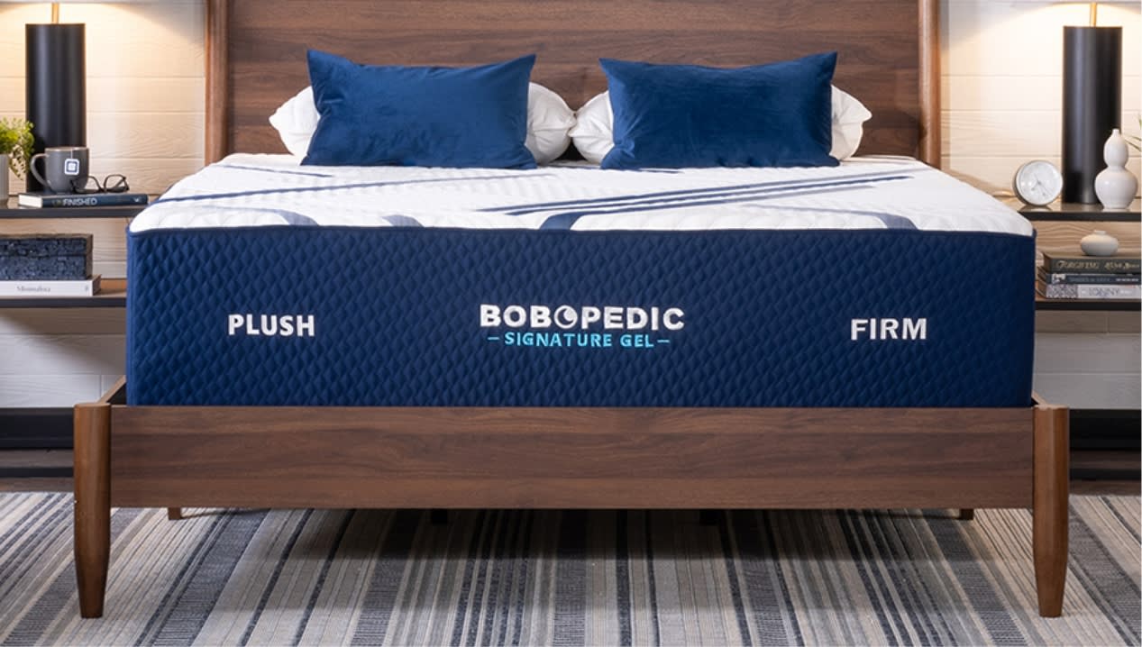 White and blue mattress on wooden bed