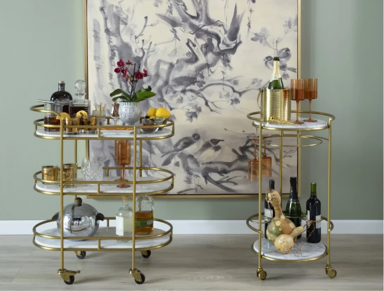 Oval and round white marble and gold bar carts stocked with everything needed for a party.