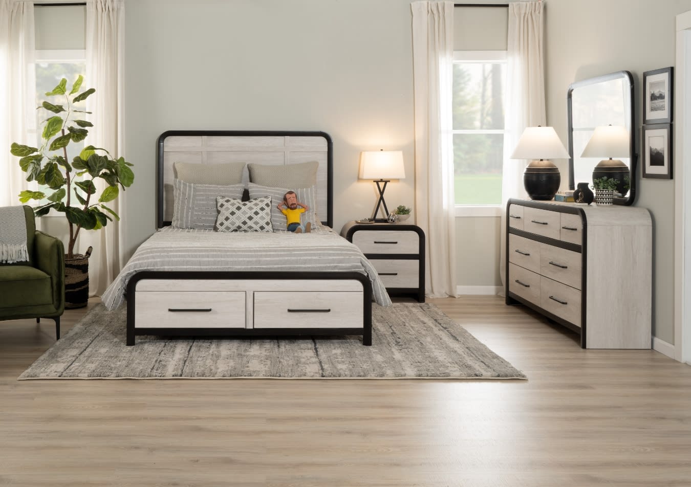Modern bedroom set with light wood and black metal frame bed, matching nightstand and dresser with mirror, neutral bedding, and soft lighting.