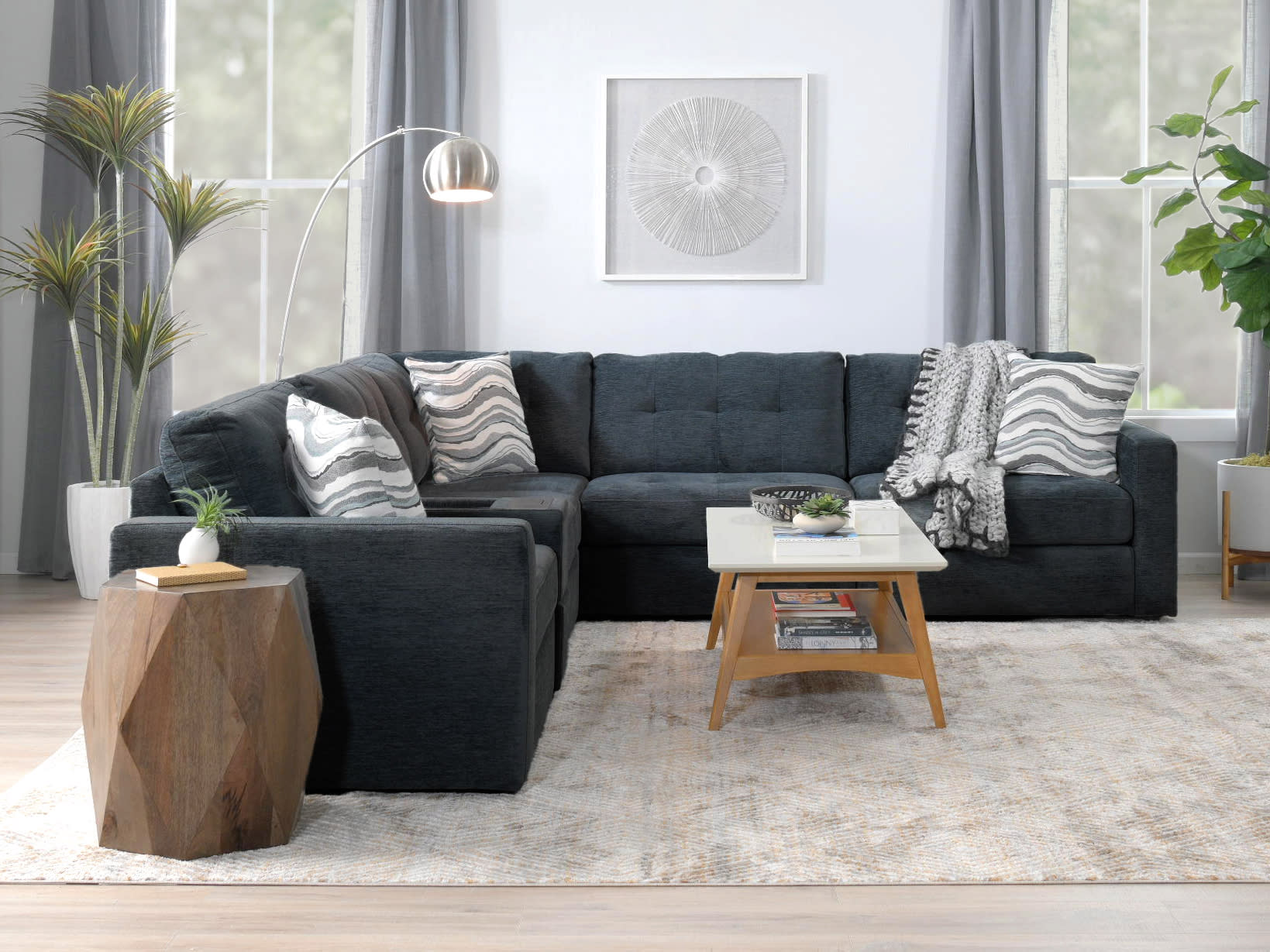 blue sectional in living room with throw pillows and marble coffee table