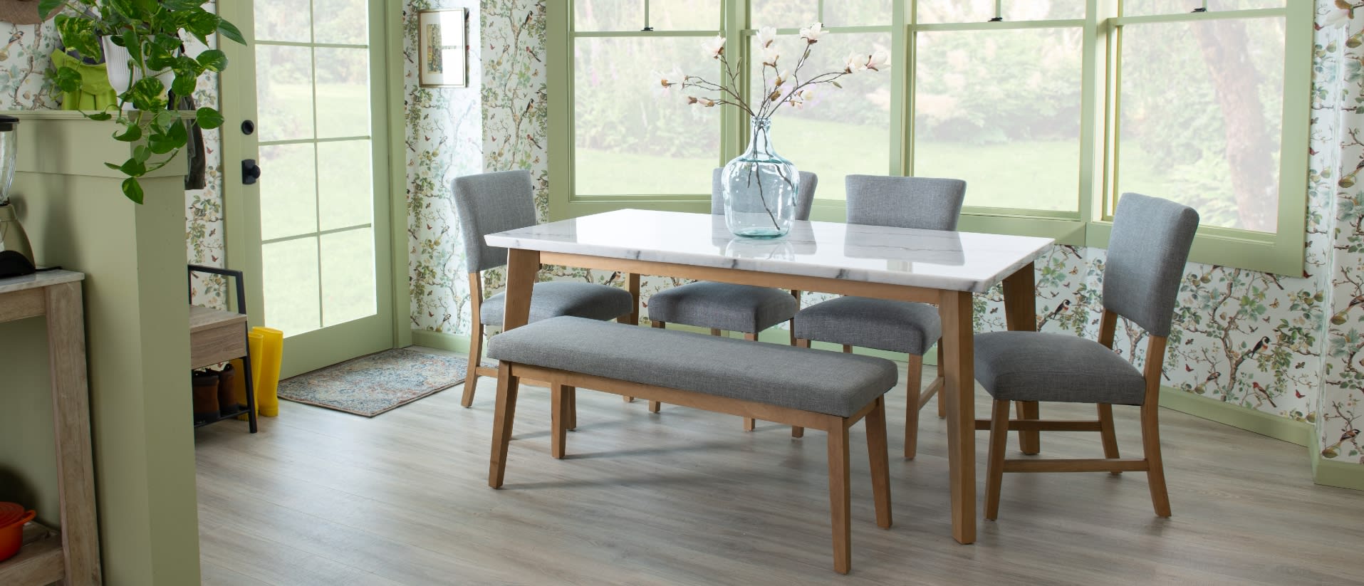 White marble dining table set with gray upholstered chairs and bench