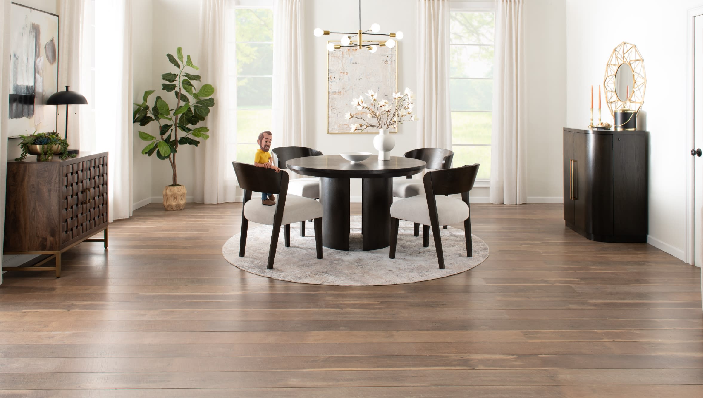 Modern dining room with dark wood round table and four cushioned chairs on a light patterned round rug, featuring large windows and minimalist decor.