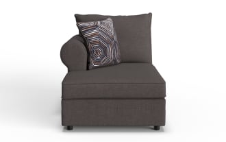 Dark gray fabric chaise lounge with a rounded left armrest, matching back cushion, and a decorative geometric patterned throw pillow.