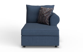 Blue fabric chaise lounge with a cushioned backrest, rounded armrest on the right, and a decorative geometric patterned throw pillow.