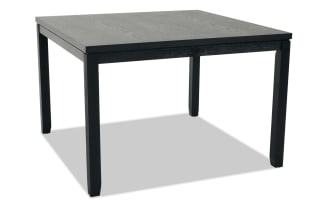 Black wooden dining table with a simple rectangular design, four sturdy legs, and a smooth flat top, suitable for modern interiors.