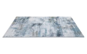 Abstract area rug with a distressed pattern in shades of blue, gray, and beige, featuring a soft, textured surface suitable for modern home decor.