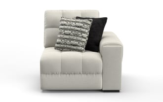 Modern light gray fabric sectional sofa corner with tufted cushions and two decorative throw pillows, one black and one patterned.
