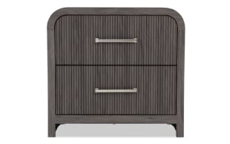 Dark gray wooden nightstand with two vertically grooved drawers, silver metal handles, and rounded top corners, modern style.