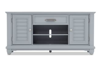 Gray wooden TV stand with two shutter-style cabinet doors, one center drawer, and open shelving with cable management hole.