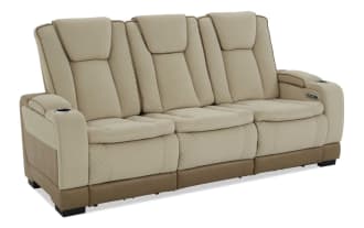 Beige and brown three-seater leather recliner sofa with quilted stitching, padded headrests, and armrest cup holders, modern living room furniture.