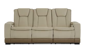 Beige and brown three-seater leather recliner sofa with quilted stitching, padded headrests, and armrest cup holders, modern living room furniture.