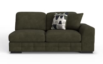 Dark olive green fabric loveseat sofa with thick cushions, wide armrest on the right, and two decorative pillows including one with geometric patterns.