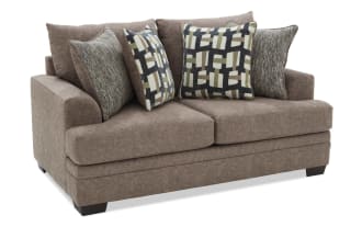 Brown fabric loveseat with four decorative cushions featuring geometric and textured patterns, designed for modern living room seating.