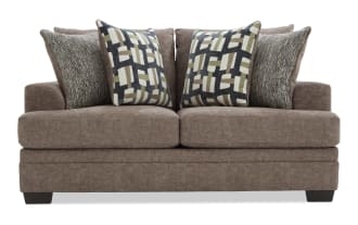 Brown fabric loveseat with four decorative cushions featuring geometric and textured patterns, designed for modern living room seating.
