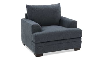 Dark gray upholstered armchair with plush cushions, wide seat, and wooden block legs, designed for comfortable living room seating.
