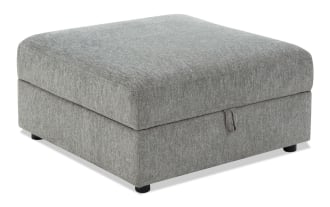 Gray fabric upholstered storage ottoman with a cushioned top, rectangular shape, and black cylindrical legs for living room seating and storage.
