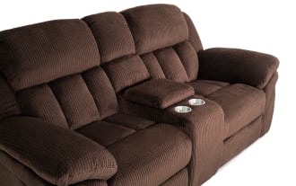 Brown plush fabric reclining loveseat with padded armrests and center console, designed for comfort and relaxation in living rooms.