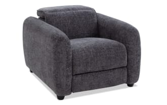 Dark gray fabric upholstered armchair with rounded, plush armrests and a cushioned backrest, featuring short black legs and a modern, cozy design.