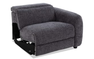 Dark gray upholstered modern corner sofa chair with plush cushioning, rounded armrest, and short black legs, suitable for living room seating.