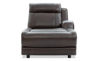 Dark brown leather recliner chair with padded armrests and cushioned backrest, featuring detailed stitching and modern design.