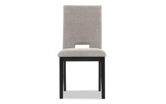 Upholstered dining chair with beige fabric seat and backrest, black wooden legs, and a modern cutout design on the lower backrest.