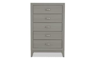 Gray wooden chest of drawers with five metal handles, featuring a modern design and raised legs for bedroom storage.