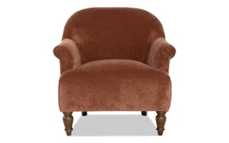 Brown velvet upholstered armchair with rounded back and rolled arms, featuring turned wooden legs in a classic style.