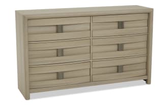 Light wood dresser with six drawers arranged in two columns and three rows, featuring simple rectangular metal handles and a smooth, modern finish.