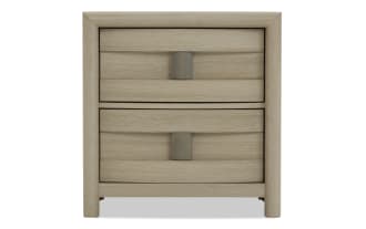 Light wood nightstand with two horizontal drawers, curved edges, and rectangular metal handles, featuring a modern minimalist design.