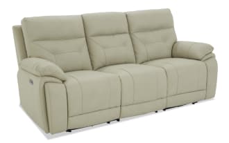 Beige leather reclining three-seater sofa with padded armrests and cushioned backrests, designed for living room comfort and style.